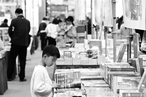 11月15日,2025中国黄山书会在安徽合肥滨湖国际会展中心开幕。图为当日,一名小朋友在书会上阅读。新华社发